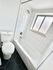 Modern bathroom featuring a sleek white bathtub, elegant geometric floor tiles, and a bright window for natural light.