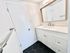 Sleek bathroom featuring a stylish vanity with a large mirror and hexagonal black tile flooring.