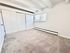 Bright and spacious carpeted bedroom with large closets, expansive window, and modern white trim.
