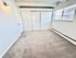 Bright, spacious bedroom with plush carpeting and large window featuring elegant blinds, enhancing natural light and offering a modern, cozy feel.