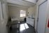 Bright and practical laundry room equipped with modern washing machines, ample natural light from a large window, and a convenient workspace.