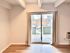 Bright living space with large sliding glass doors leading to a private balcony, offering a serene outdoor view.