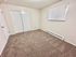 Bright and inviting bedroom with cozy carpeting, large window blinds, and ample closet space.