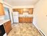 Charming kitchen with classic wooden cabinetry, sleek countertops, and tiled flooring, creating a warm and inviting cooking space.