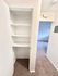 Inviting hallway with plush carpet and built-in shelving for convenient storage.