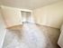 Bright, spacious room with soft carpeting and neutral-toned walls, perfect for customization and creating a cozy living area.
