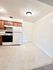 Inviting kitchen area with sleek wooden cabinets, modern white appliances, and ample natural light.