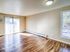 Bright and airy living room with sleek hardwood floors and large windows, perfect for relaxing and entertaining.