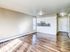 Bright open-concept living area with modern hardwood flooring and a sleek kitchen layout.