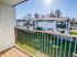 Bright and inviting balcony view overlooking a well-maintained building and sunny green lawn.