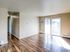 Bright living space with sleek hardwood floors and ample natural light through large sliding glass doors.