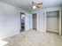 Spacious bedroom with plush carpeting, dual closets, and modern ceiling fan, offering comfort and style.