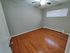 Bright and spacious bedroom with polished hardwood floors, modern ceiling fan, and natural light filtering through the window blinds.