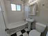 Charming bathroom with elegant black and white checkered flooring, classic white fixtures, and a bright window offering natural light.