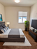 Bright and inviting bedroom featuring a cozy bed with elegant linens, a large window with natural light, and stylish decor.
