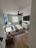 Inviting bedroom featuring a stylish modern bed, cozy lighting, a large window for natural light, and elegant decor with a wall-mounted TV.