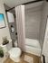 Elegant bathroom featuring a modern bathtub with curtain, chic grey tiled walls, and stylish decor accents.