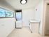 Bright laundry room with modern stacked washer and dryer, ample countertop space, and large window for natural light.