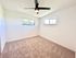 Bright and airy bedroom featuring large windows, plush carpeting, and a modern ceiling fan.