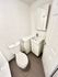 Contemporary bathroom with sleek fixtures, featuring a compact toilet and chic pedestal sink for an elegant touch.