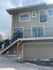 Charming two-story home with large windows, a private balcony, and attached garage in a serene neighborhood.