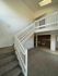 Inviting two-story apartment with elegant staircase and open kitchen design, featuring natural light and spacious carpeted living area.