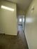 Bright hallway with plush carpeting leading to a cozy room with natural light from the door window.