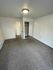 Bright bedroom with plush carpeting, mirrored closet doors, and modern ceiling light.