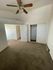 Bright and airy bedroom with plush carpeting, dual closets, and a stylish ceiling fan for modern comfort.