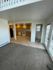 Bright and open living area with plush carpet and tile flooring, connecting to a well-equipped kitchen featuring wooden cabinets and modern appliances.