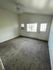 Bright and spacious room with plush carpeting, large windows, and ceiling fan, offering comfort and ample natural light.