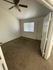 Inviting bedroom with plush carpet, ceiling fan, and large window offering natural light.