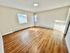 Bright, spacious room with modern wood flooring and ample natural light.