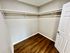 Spacious walk-in closet with sleek wooden flooring and ample hanging space.