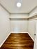 Spacious walk-in closet with wooden flooring and ample hanging space.