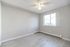 Bright and airy bedroom with large window, ceiling fan, and fresh flooring, perfect for creating your dream space.