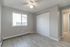 Bright and airy bedroom with modern flooring, fresh paint, and a large window offering natural light.