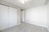 Bright and airy empty bedroom with sleek hardwood floors and double sliding closet doors.