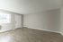 Bright and inviting empty room with large window, modern light wood flooring, and neutral walls, offering a versatile and open layout.
