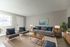 Modern living room with gray sofa, stylish chairs, a cozy rug, and elegant decor in a bright, inviting space.