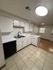 Modern kitchen with sleek white cabinets, dual sinks, and elegant tile flooring, perfect for culinary creativity.