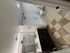 Modern bathroom featuring a double vanity with sleek black fixtures, elegant lighting, spacious bathtub, and stylish tile flooring.