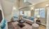 Bright and inviting living room with high ceilings, stylish furniture, and large windows offering natural light.