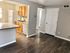 Modern kitchen with sleek wooden cabinetry, spacious countertops, and gleaming hardwood floors, offering a bright and inviting space.
