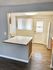 Bright kitchen area with modern lighting, compact counter space, and wood flooring, offering a cozy and functional layout.