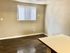Bright room with modern wood flooring and a large window for natural light, perfect for a cozy living or dining area.