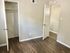 Bright, modern room showcasing stunning hardwood floors and an inviting open closet, perfect for a cozy living space.