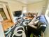 Inviting living room with modern TV setup, cozy sofa, and elegant dining area, enhanced by natural light and stylish decor.