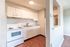 Bright and inviting kitchen with modern white cabinetry, sleek countertops, and warm wood flooring, perfect for culinary adventures.