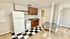 Cozy kitchen featuring modern appliances, sleek wooden cabinetry, and stylish black-and-white checkered flooring.